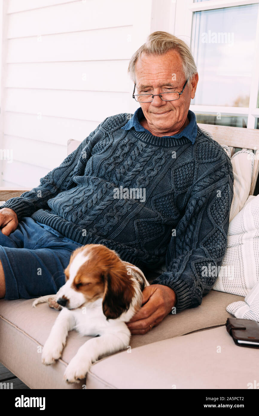 Homme assis avec dog on sofa Banque D'Images
