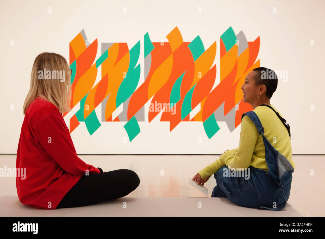 Deux femmes discutent 'Rajasthan (peinture murale), 2012' dans une rétrospective des travaux par op-Britannique Bridget RILEY spécialiste de l'art s'ouvre à la Hayward Gallery sur la rive sud. Banque D'Images