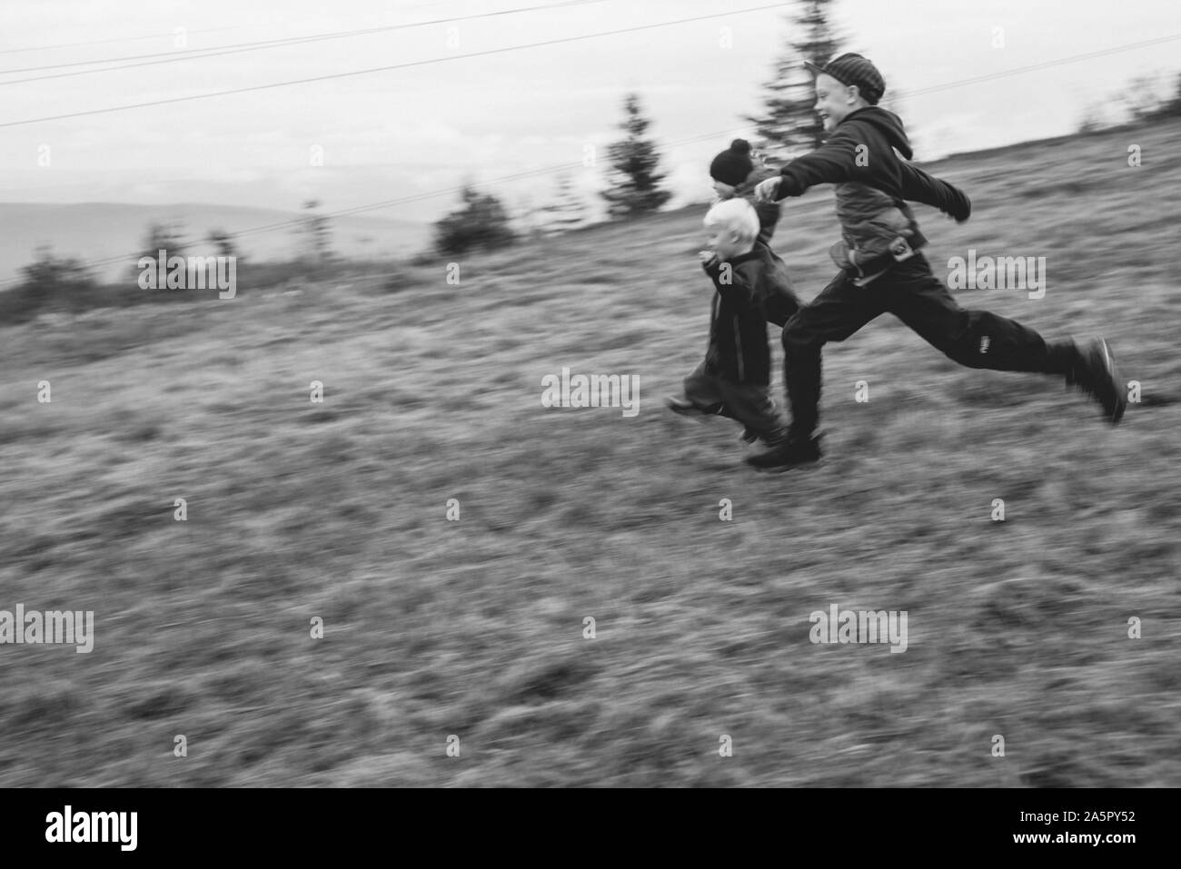 Enfants qui courent à travers la prairie Banque D'Images