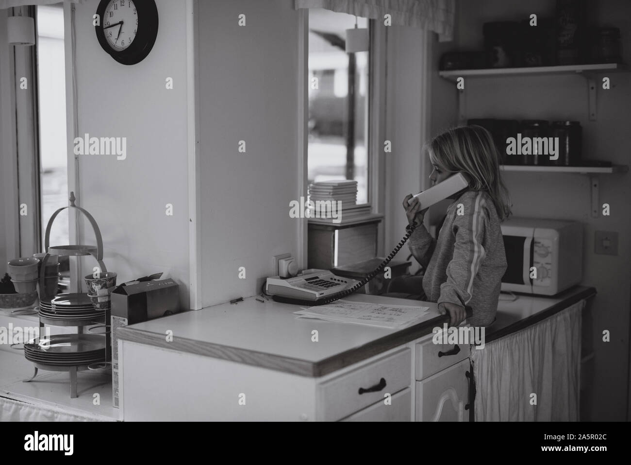 Girl en utilisant la téléphonie par câble dans la cuisine Banque D'Images
