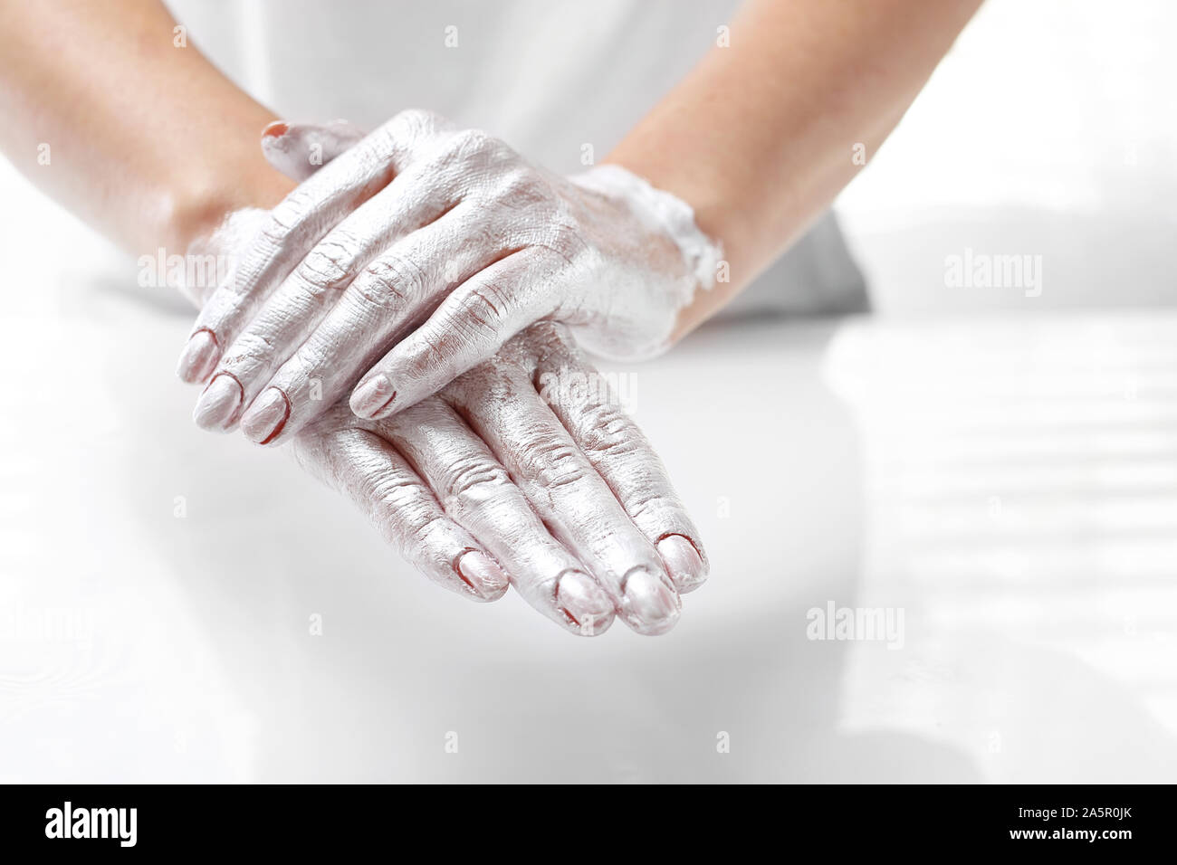 Belle et lisse la peau à la main. La femme met un masque sur la peau de la main. Soins de la peau à la main. Banque D'Images
