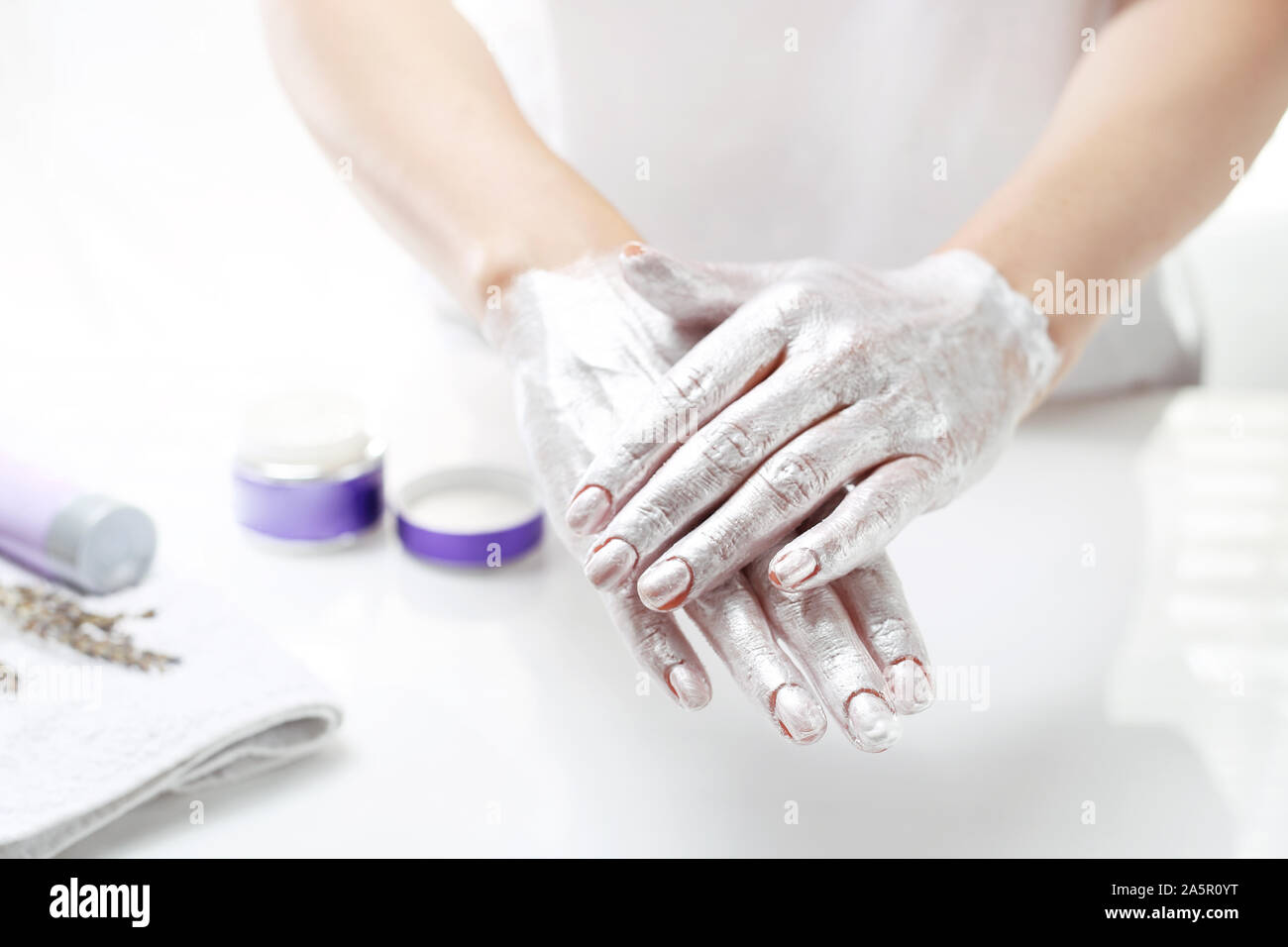 Côté spa. La femme met un masque sur la peau de la main. Soins de la peau à la main. Banque D'Images