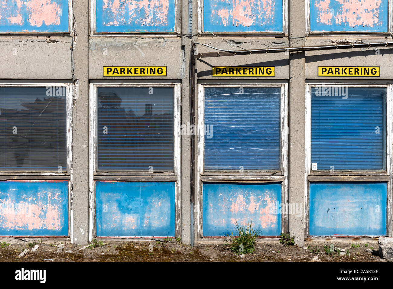 "Parkering", panneaux de stationnement en danois sur le devant d'un bâtiment délabré ; Danemark Banque D'Images