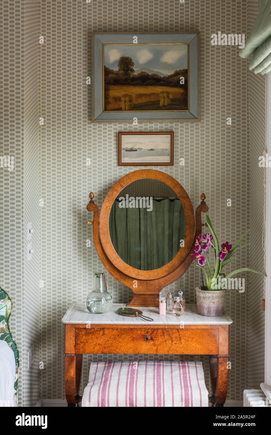 Miroir ovale recouvert de marbre sur une coiffeuse avec orchidée Banque D'Images