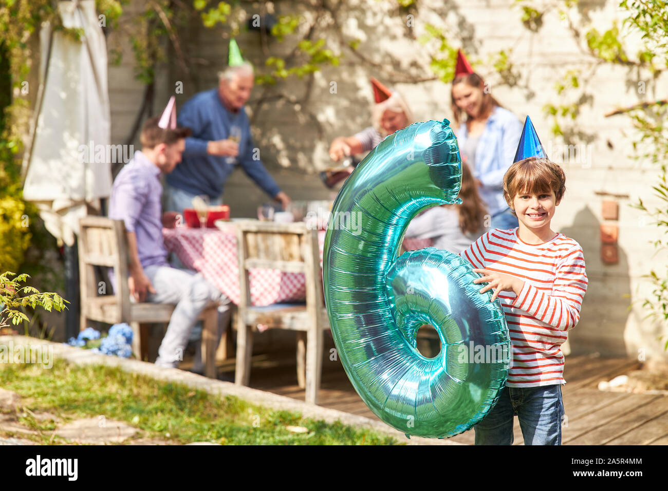 Fille d'anniversaire avec ballon en la forme d'un six dans le jardin en été Banque D'Images