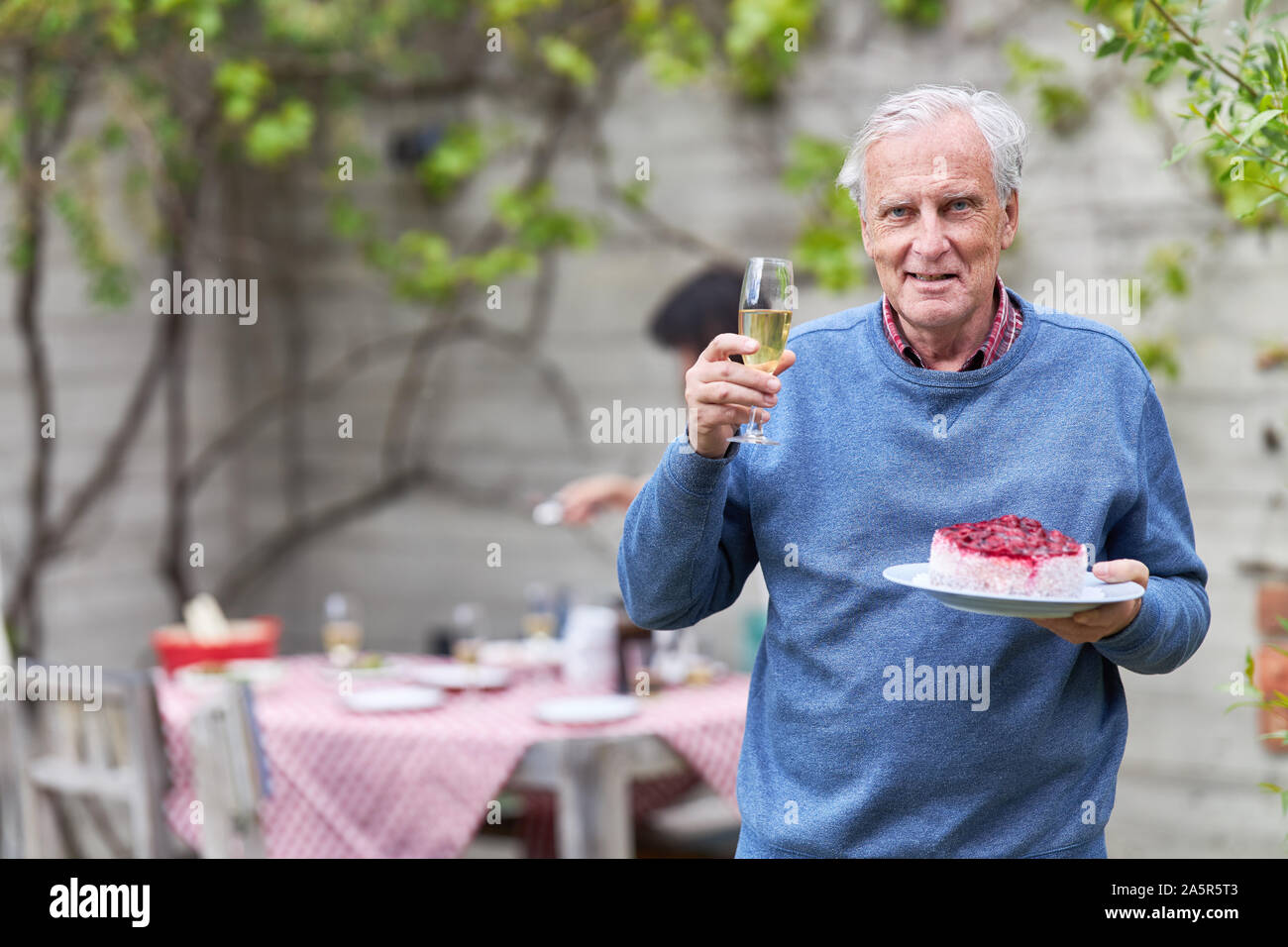 Hauts fête son anniversaire dans le jardin en été, avec des gâteaux et un verre de vin mousseux Banque D'Images