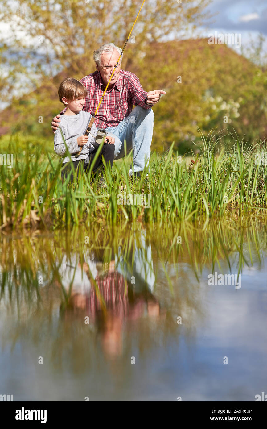 Grandpa présente son petit-fils de la pêche sur le lac en été sur le week-end Banque D'Images