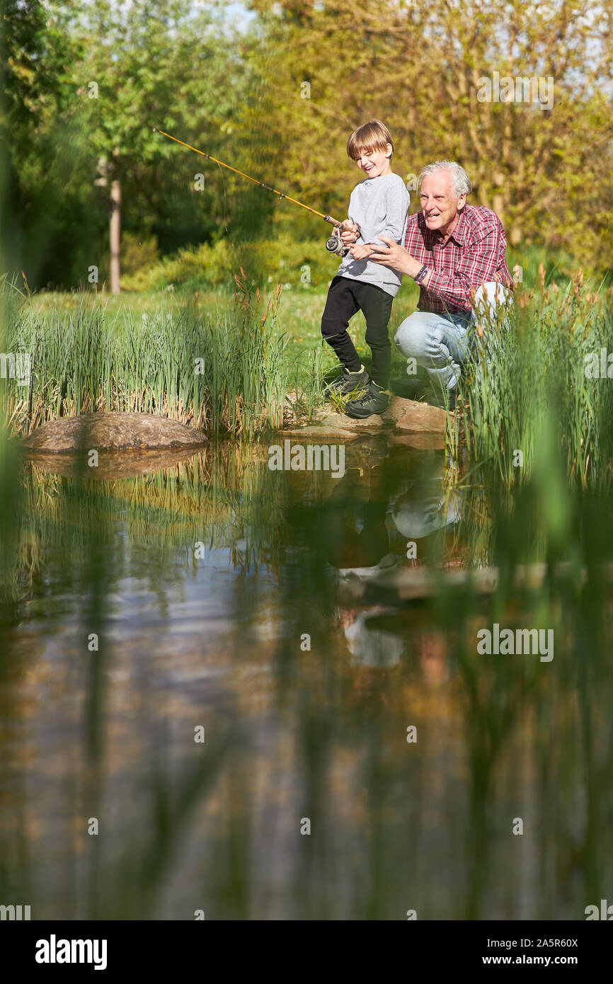 Grand-père apporte son petit-fils de la pêche sur le lac en été sur le week-end Banque D'Images