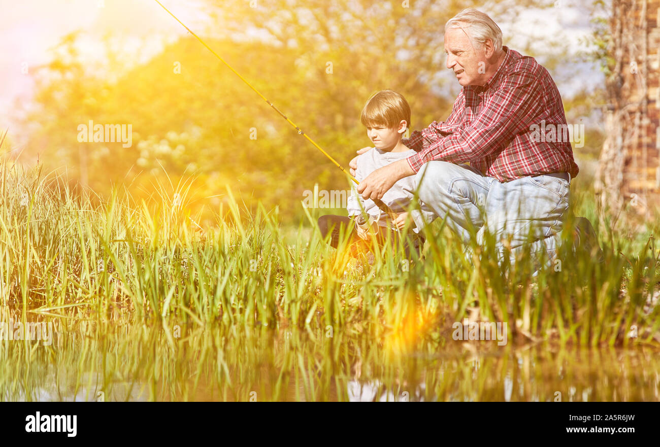 Grand-père et petit-fils de pêche ensemble car les pêcheurs sur le lac en été Banque D'Images