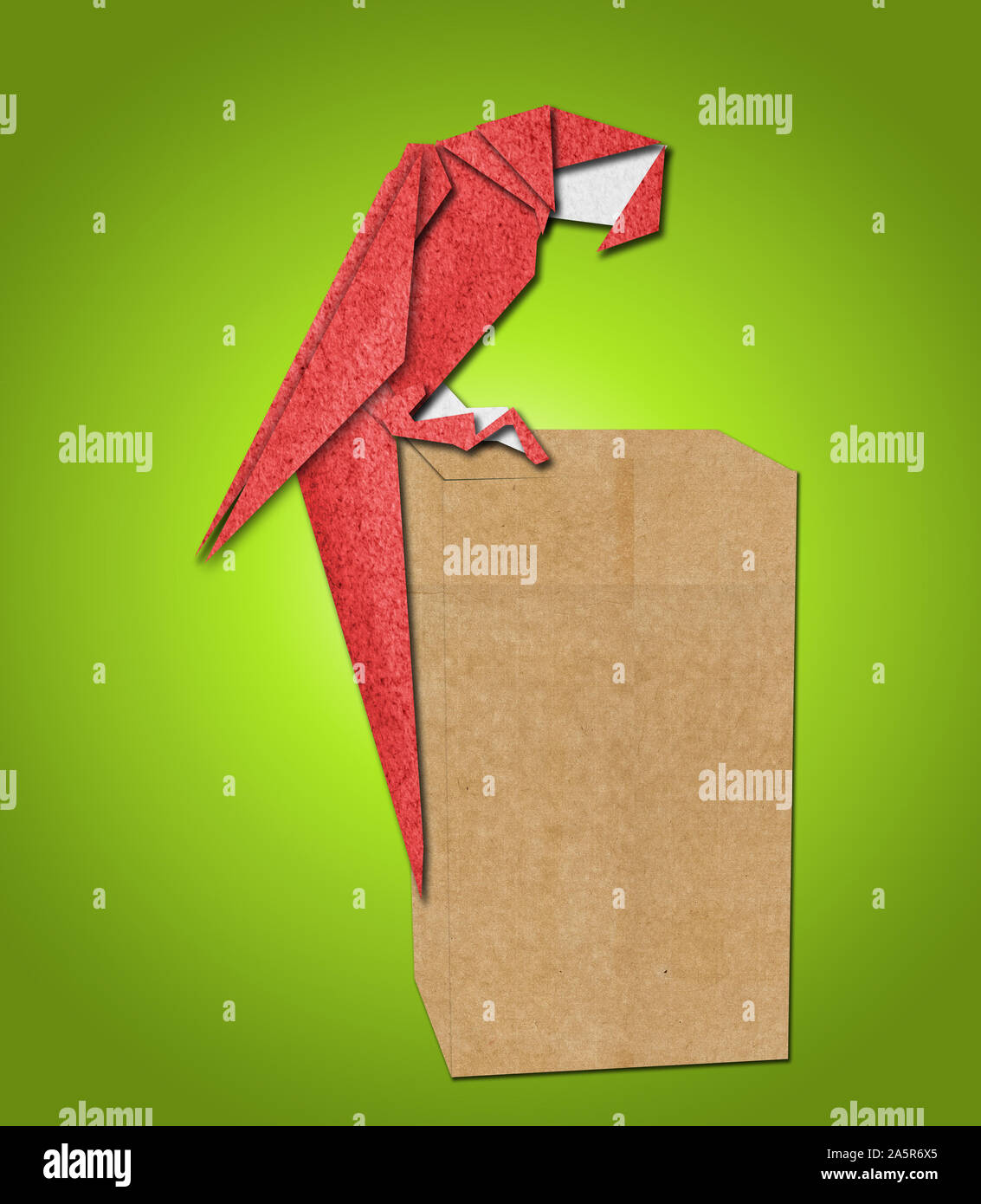 Perroquet origami en papier sur fond vert Banque D'Images