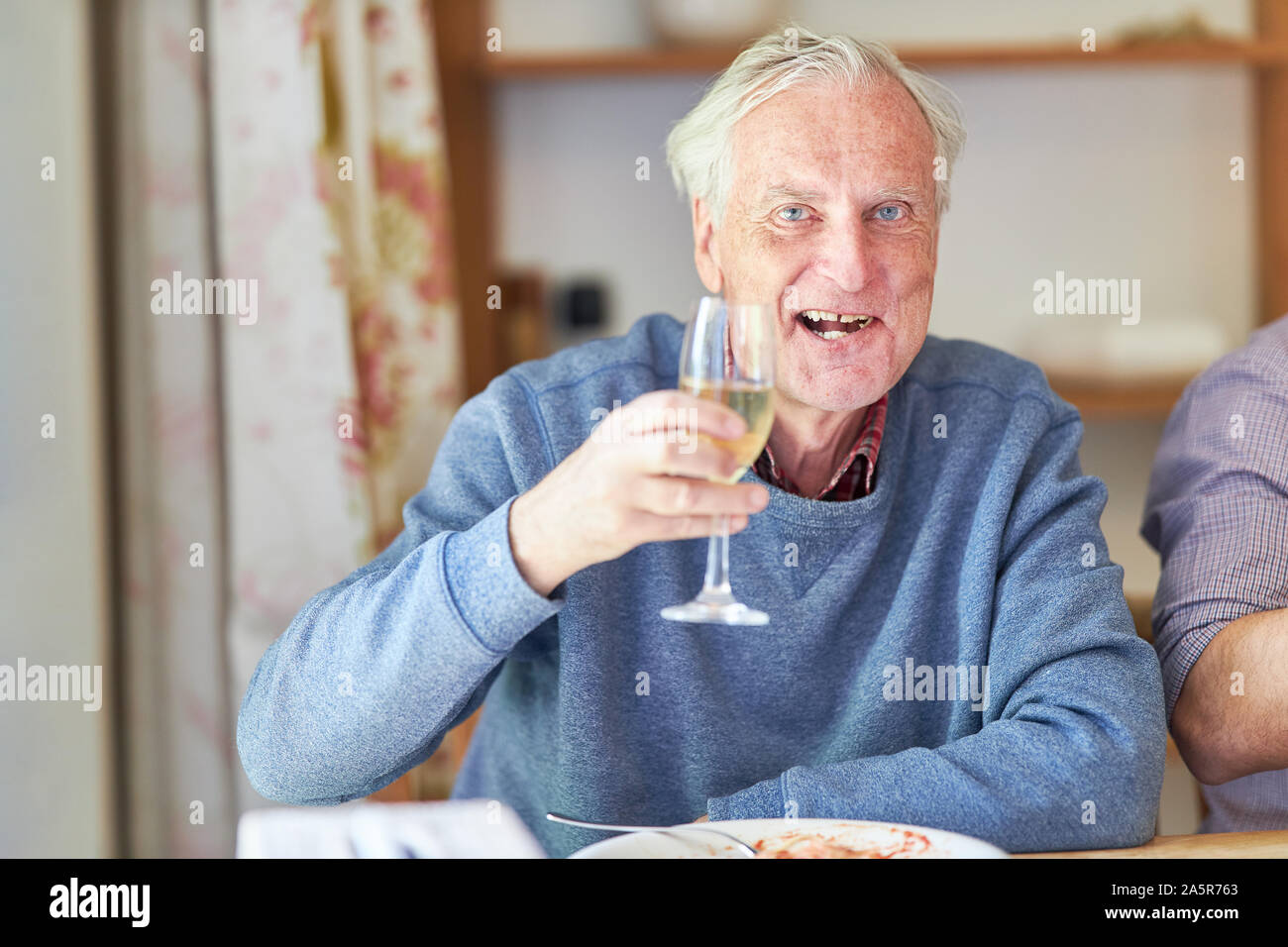 Happy senior avec le verre à champagne à une fête de famille Banque D'Images