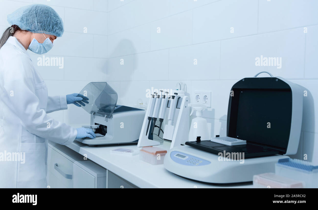 Jeune femme travaillant dans un laboratoire moderne et à l'aide d'analyzer Banque D'Images