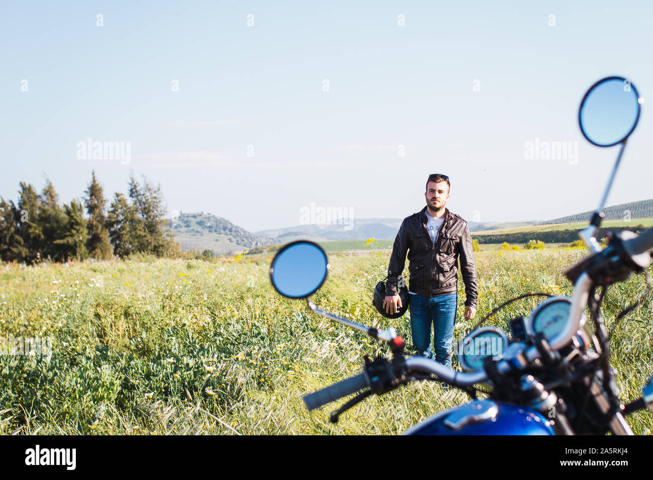 Jeune homme monté sur son vélo dans la campagne, portant le casque du t Banque D'Images