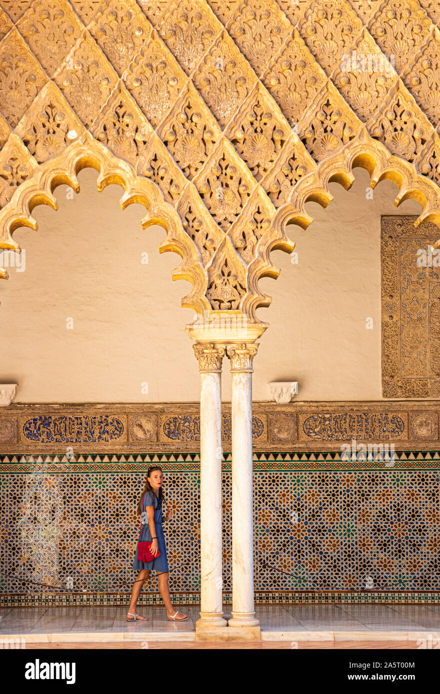 Une femme marche sous arcades du Patio de las palais Alcazar demoiselles de l'Alcazar de Séville Séville Royal Alcázar de Séville espagne andalousie Banque D'Images