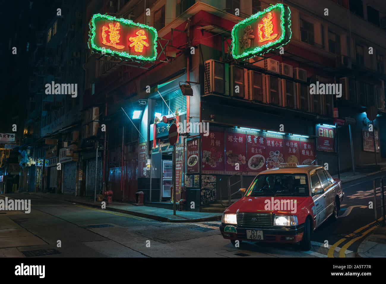 Taxi rouge à Hong Kong ci-dessous les enseignes au néon de couleur et les entreprises de publicité des restaurants. Banque D'Images