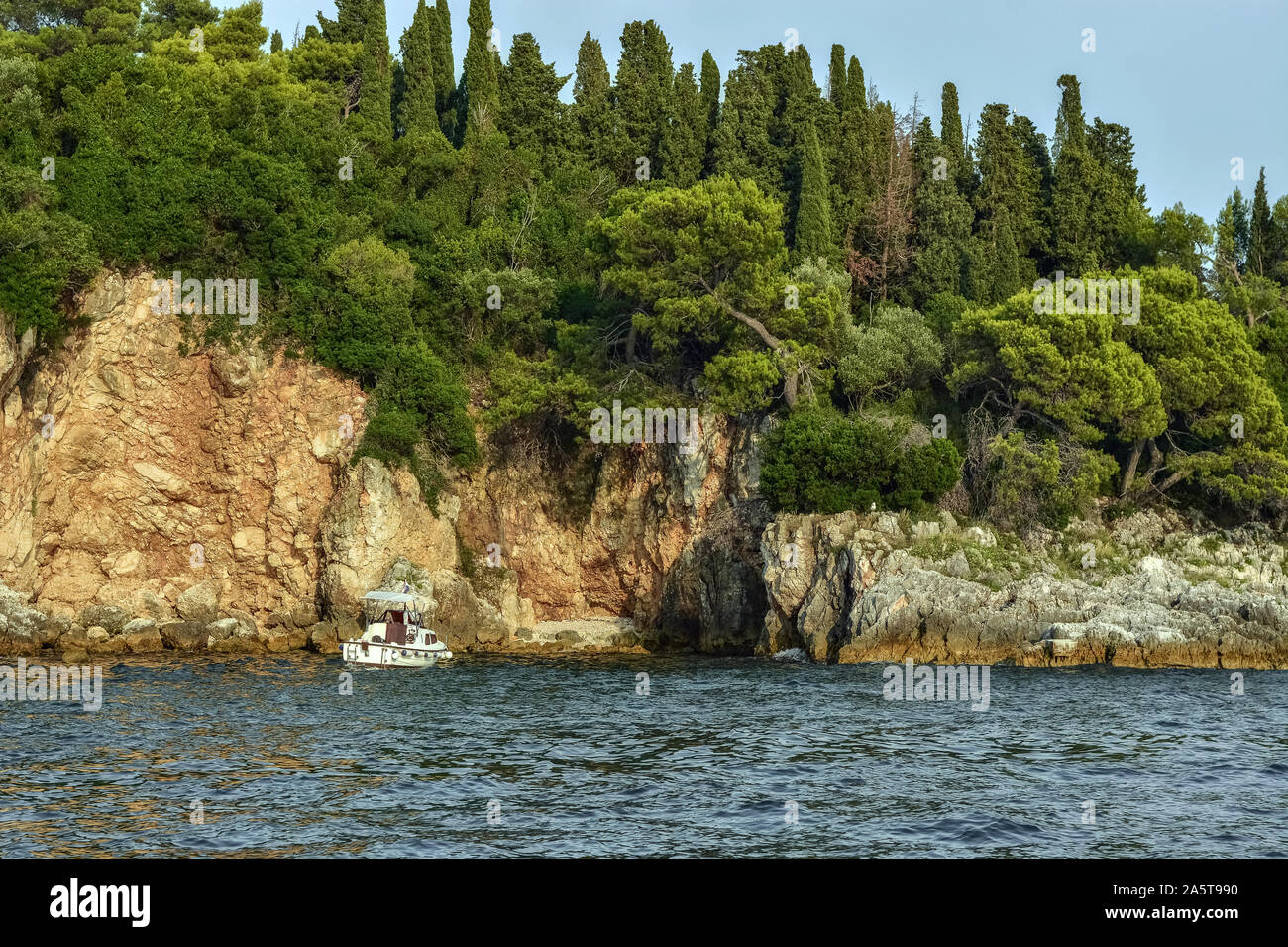 Confortable calme Baie avec un bateau sur les rives rocheuses de l'île rouge en Croatie, près de la ville de Rovinj. Banque D'Images