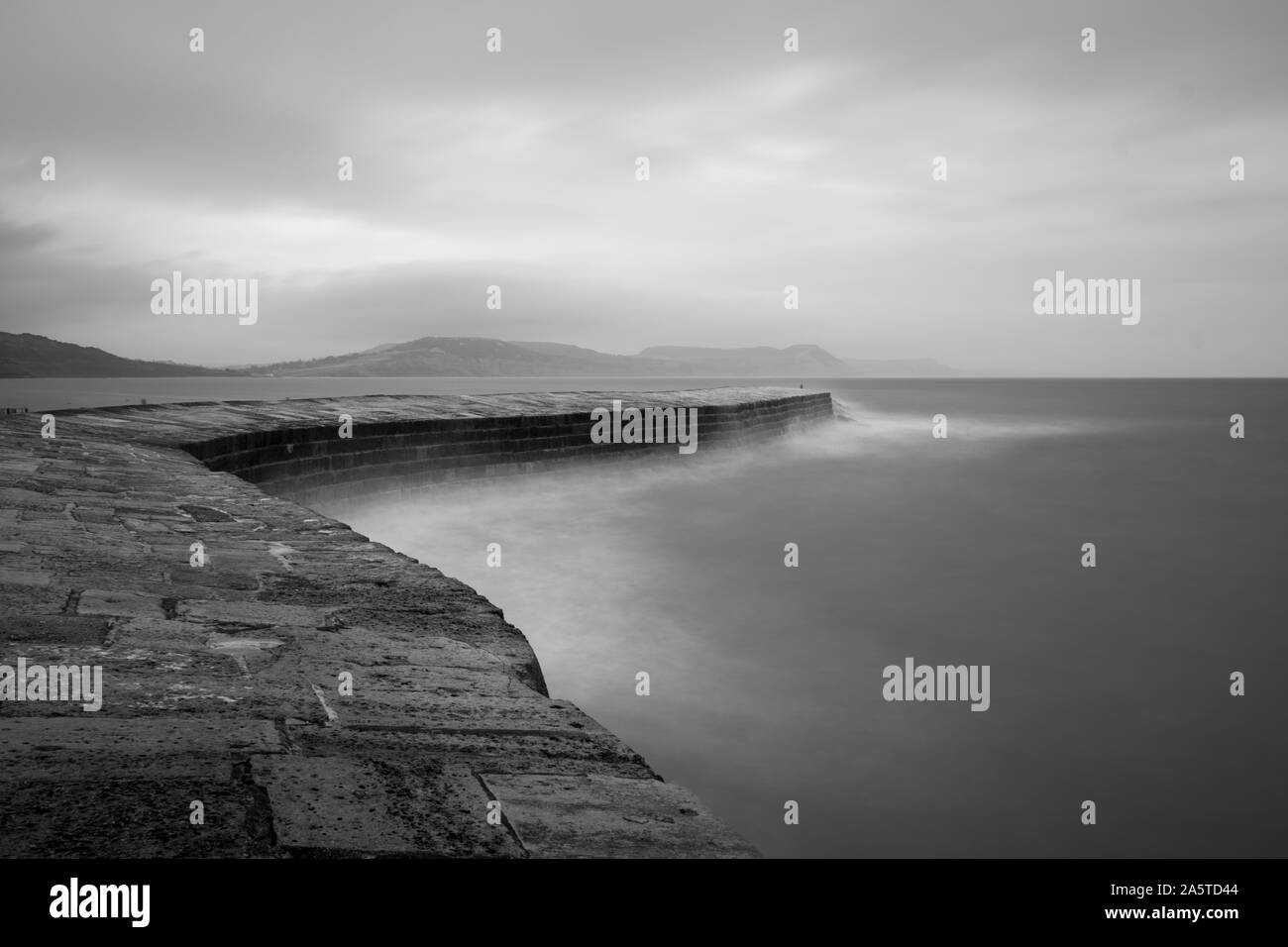 Une longue exposition de la jetée de Lyme Regis dans le Dorset en noir et blanc Banque D'Images
