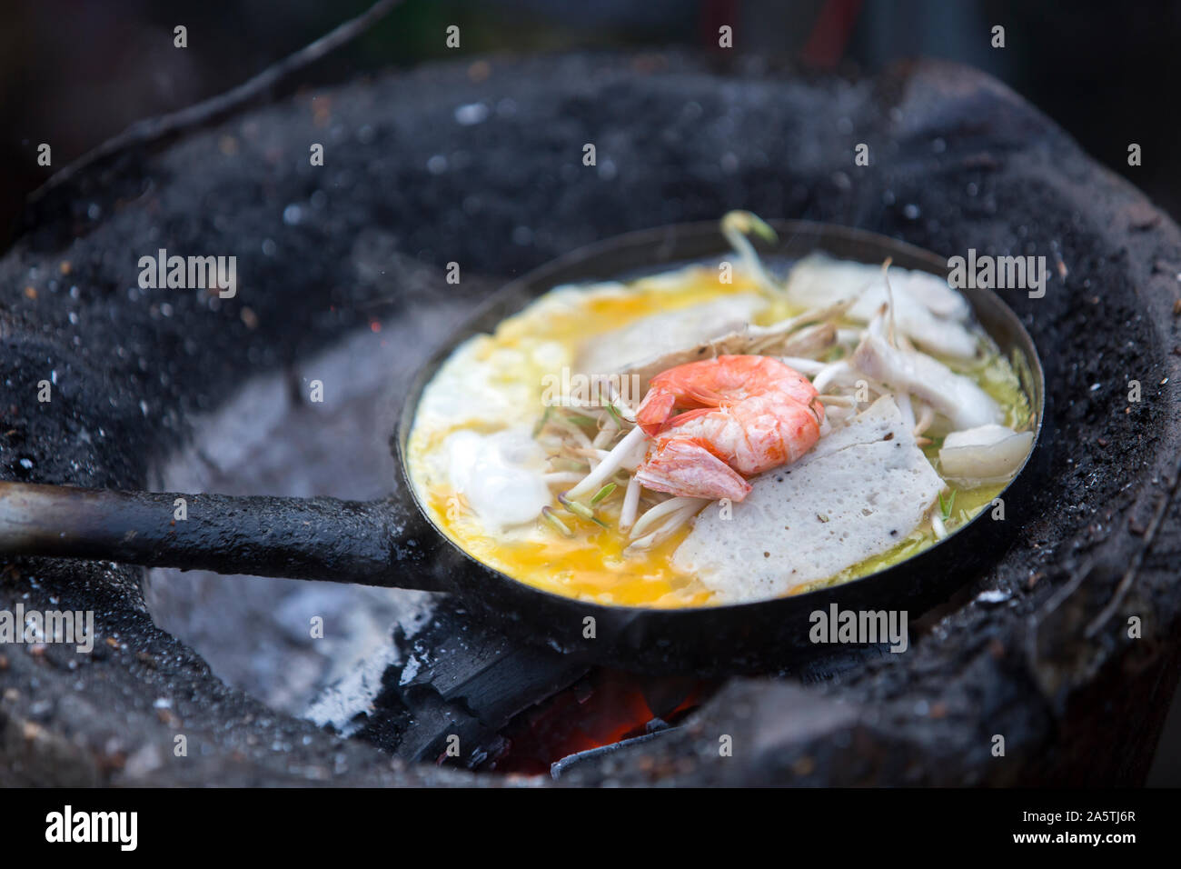 Close up de Crêpes vietnamiennes avec l'oeuf et la cuisson des crevettes dans la poêle. Banque D'Images