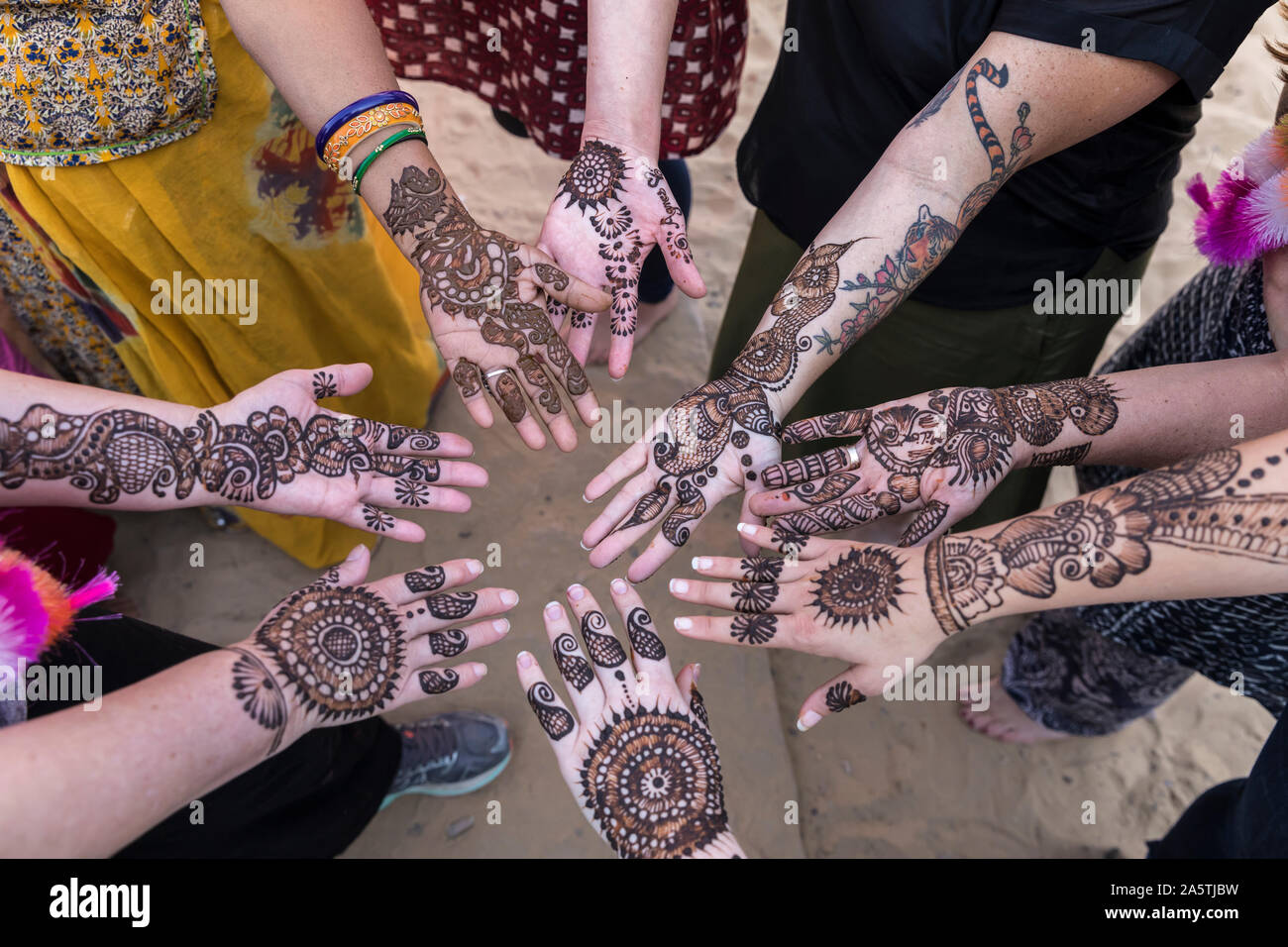 Close up de huit mains et bras avec modèles mehndi sur eux. Banque D'Images