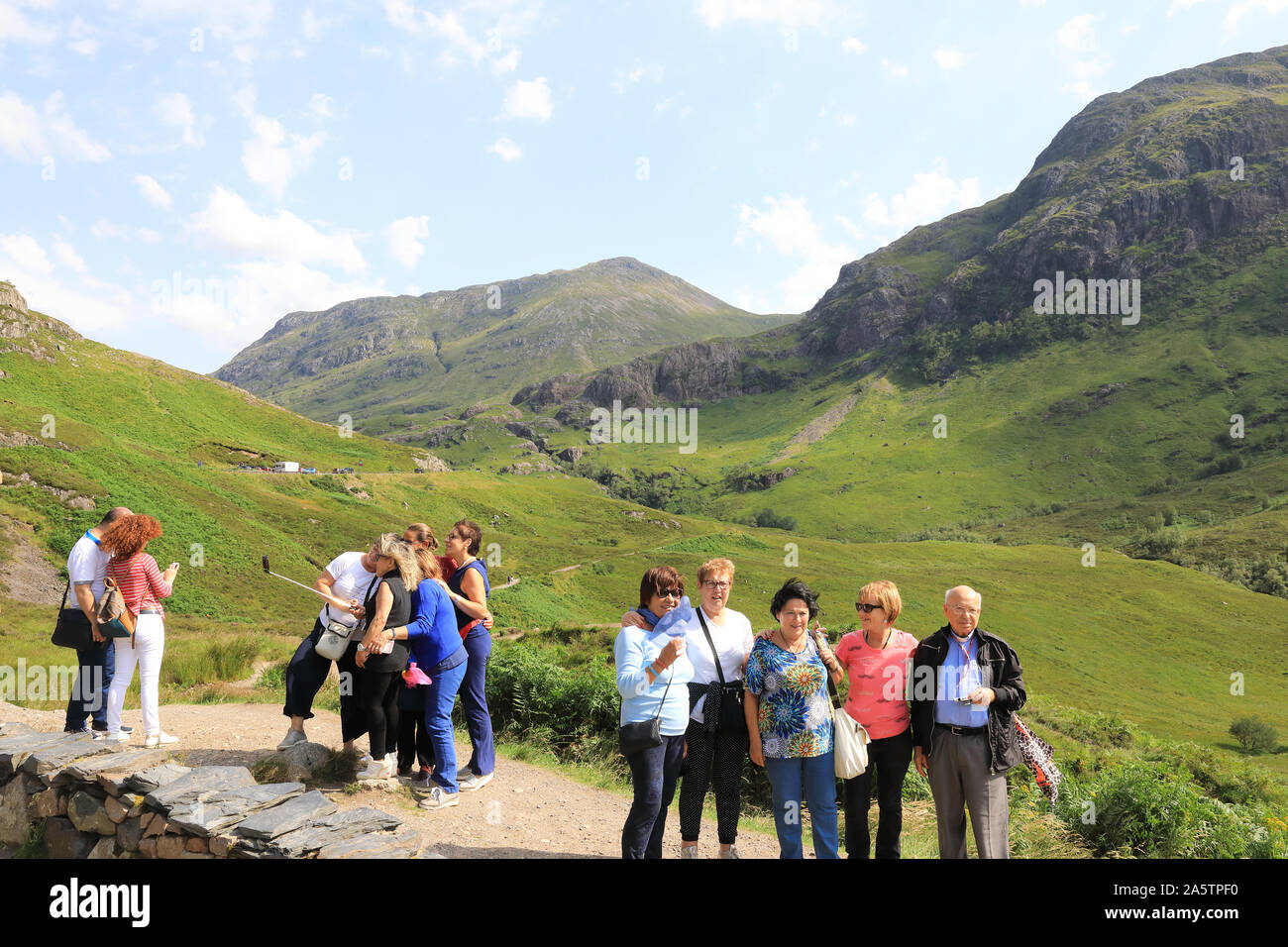 Des groupes de touristes prendre des photos lors d'un arrêt sur l'A82 dans les spectaculaires montagnes de Glencoe, dans les Highlands écossais, UK Banque D'Images