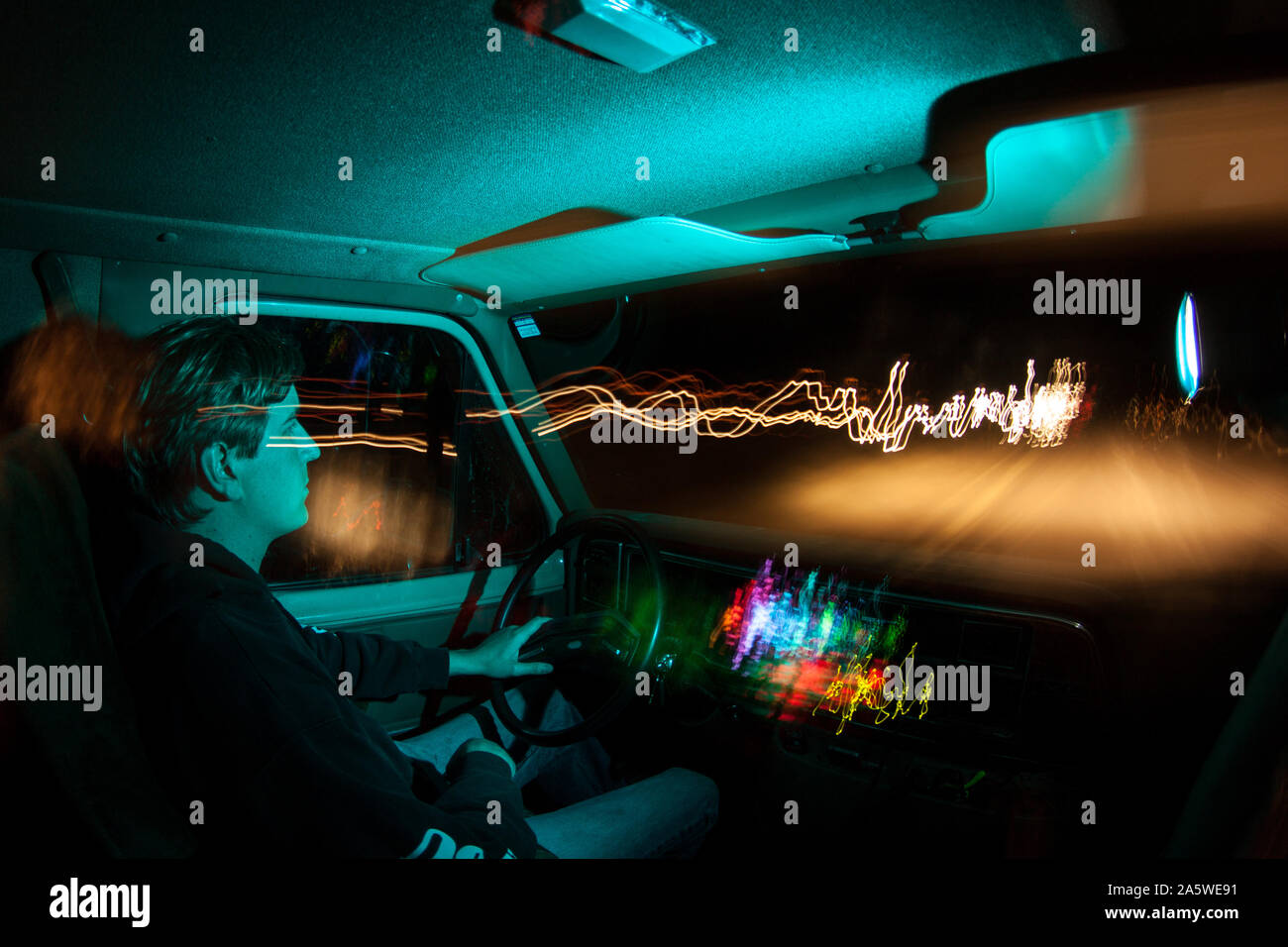 Un homme conduit un van sur l'autoroute la nuit. Banque D'Images