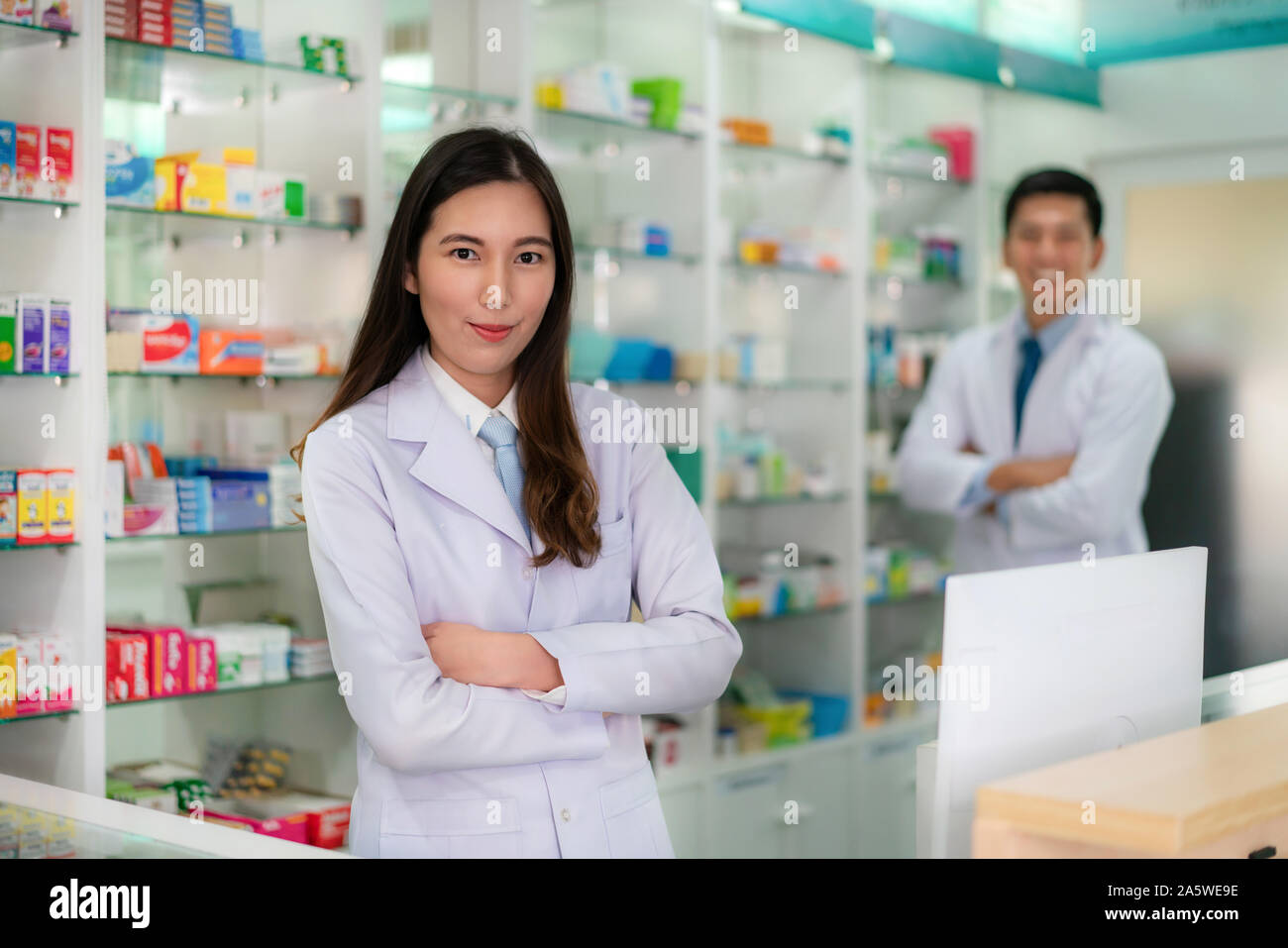 Deux jeunes asiatiques femme et homme pharmacien avec un beau sourire amical debout les bras croisés dans la pharmacie en ligne. La médecine, pharmacie, il Banque D'Images