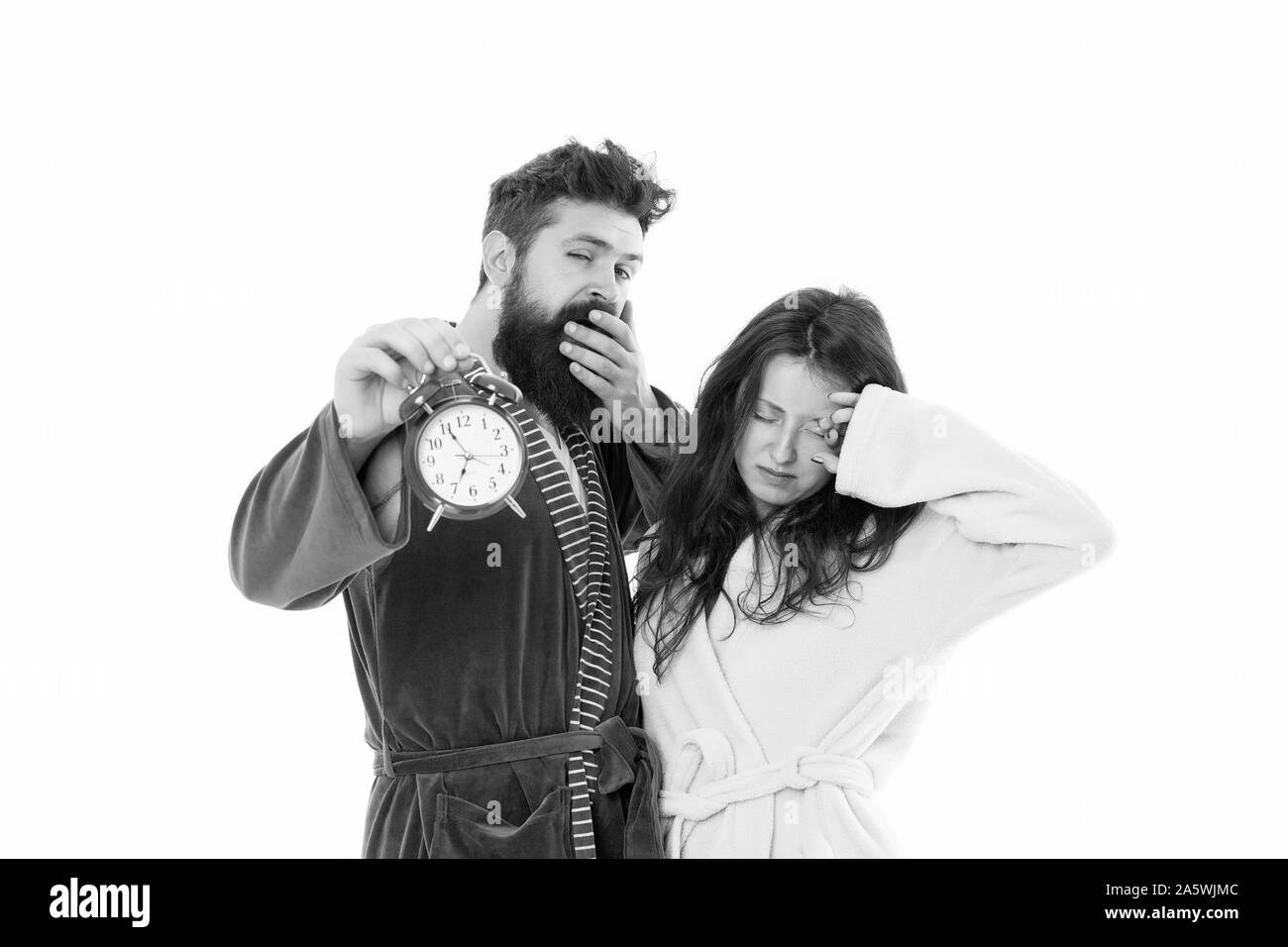 Encore une fois de mauvaise humeur. Matin alarme. Les gens endormis. Couple in love de peignoirs. Les troubles du sommeil. Somnolence et faible en matinée. La routine du matin. Réveil sonner. Sleepy Couple portez des vêtements pour dormir. Banque D'Images