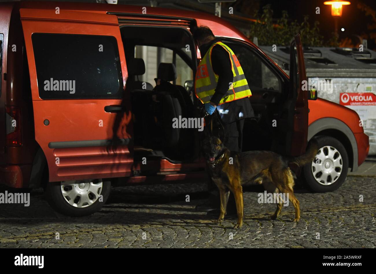 13 octobre 2019, la Bavière, Wernberg-Köblitz : un conducteur de chien de police a son chien piste drogues recherchez une voiture à un poste de contrôle de la police sur l'A93. Photo : Nicolas Armer/dpa Banque D'Images