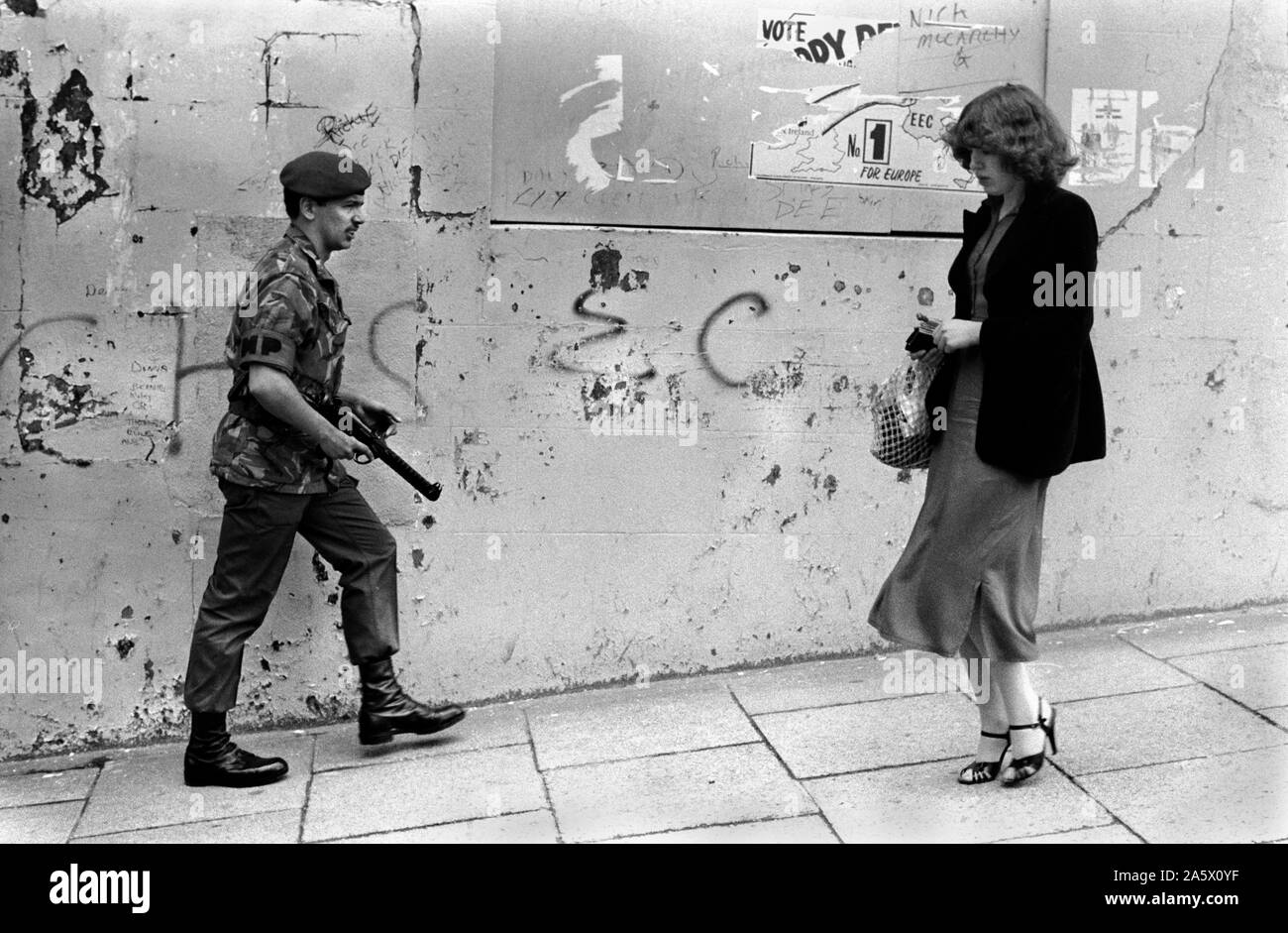 Soldats britanniques les troubles en patrouille armée à Derry, Irlande du Nord Londonderry 1970s UK. Jeune femme vantant sa vie quotidienne. 1979. HOMER SYKES Banque D'Images