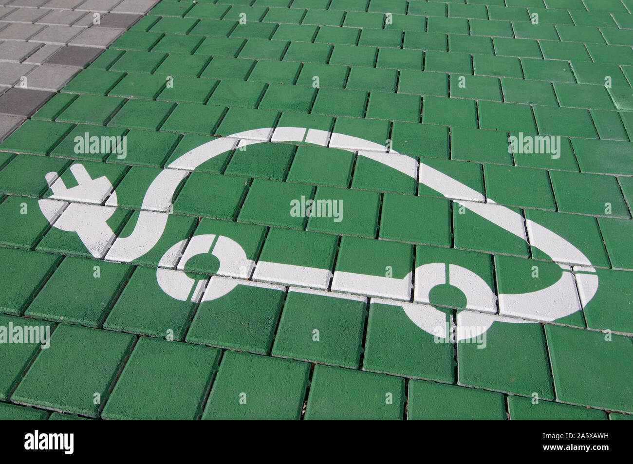 Close up photo d'une station de recharge de véhicules électriques symbole sur un fond vert, capturé à Lugano (Tessin) - Suisse Banque D'Images