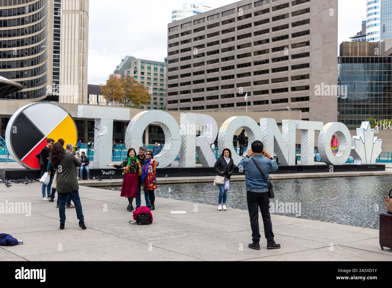 Les touristes prennent des photos devant le panneau de Toronto à l'hôtel de ville de Toronto, sur Nathan Philips Square. Banque D'Images