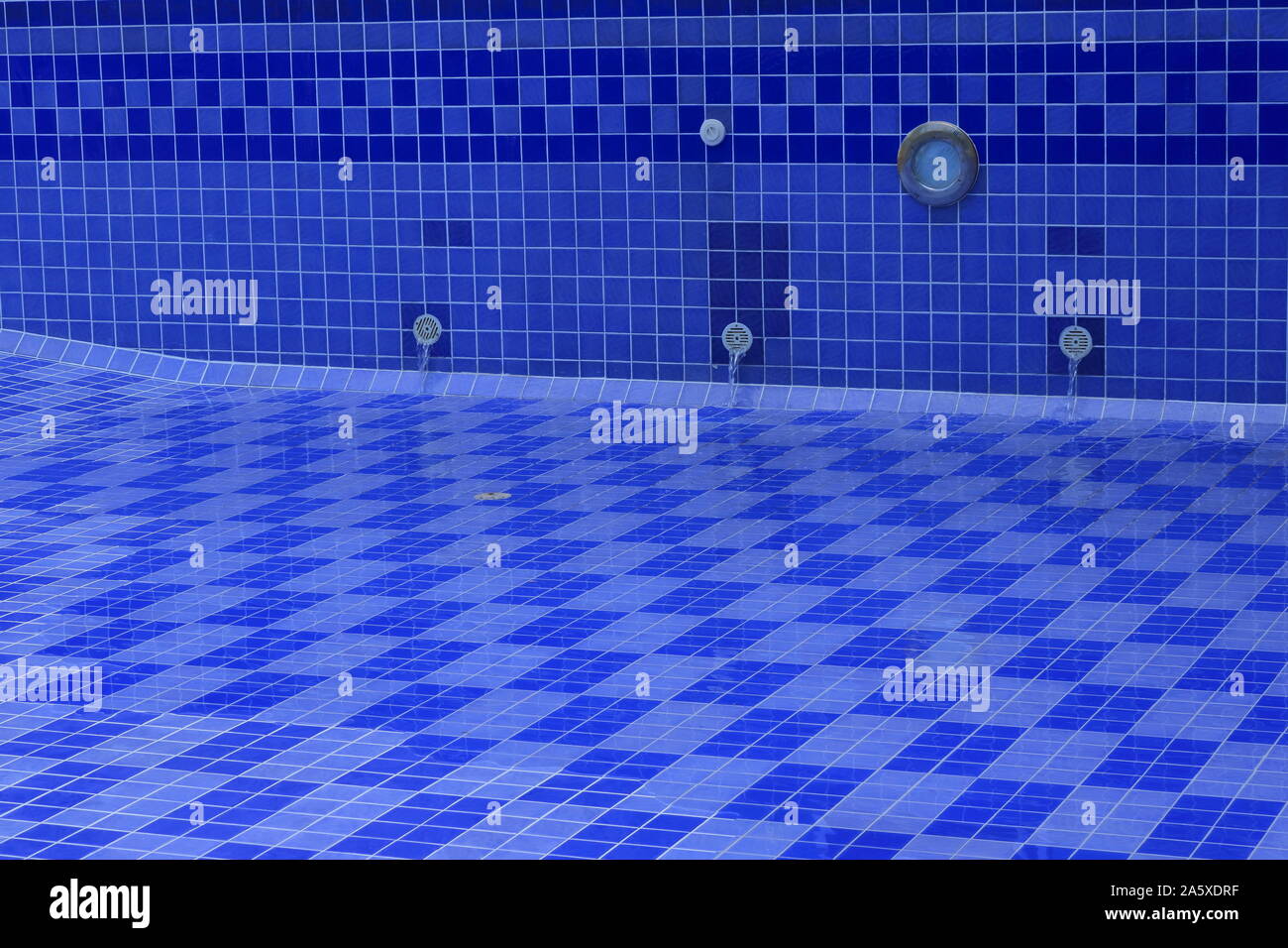 Libre cours d'eau de sortie du tuyau dans la piscine vide après la remise en état et de nettoyage, pour le concept, la métaphore Banque D'Images