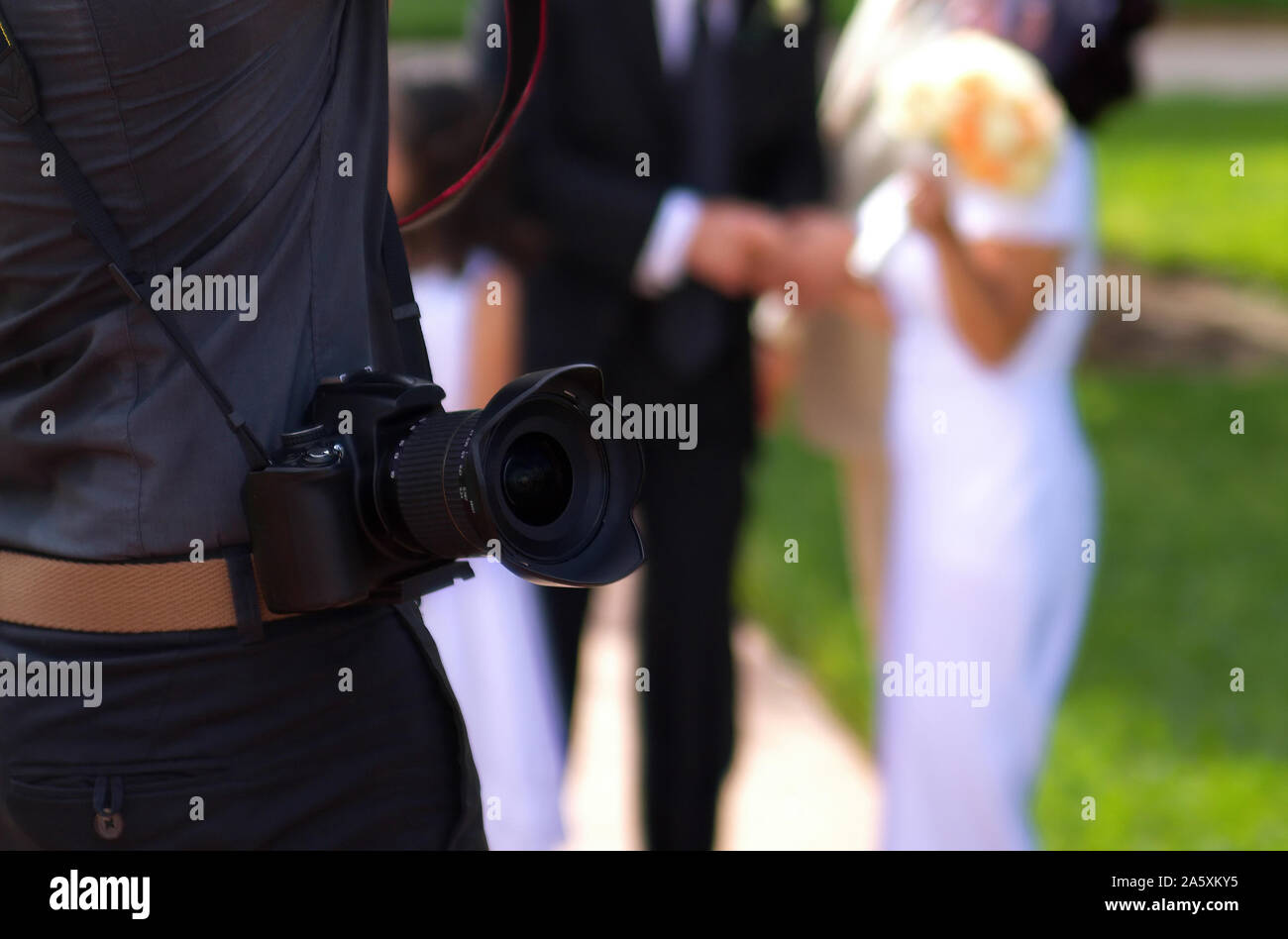Appareil photo numérique professionnel à une épaule tandis que les photographes de la transpiration pour une cérémonie de mariage. Banque D'Images