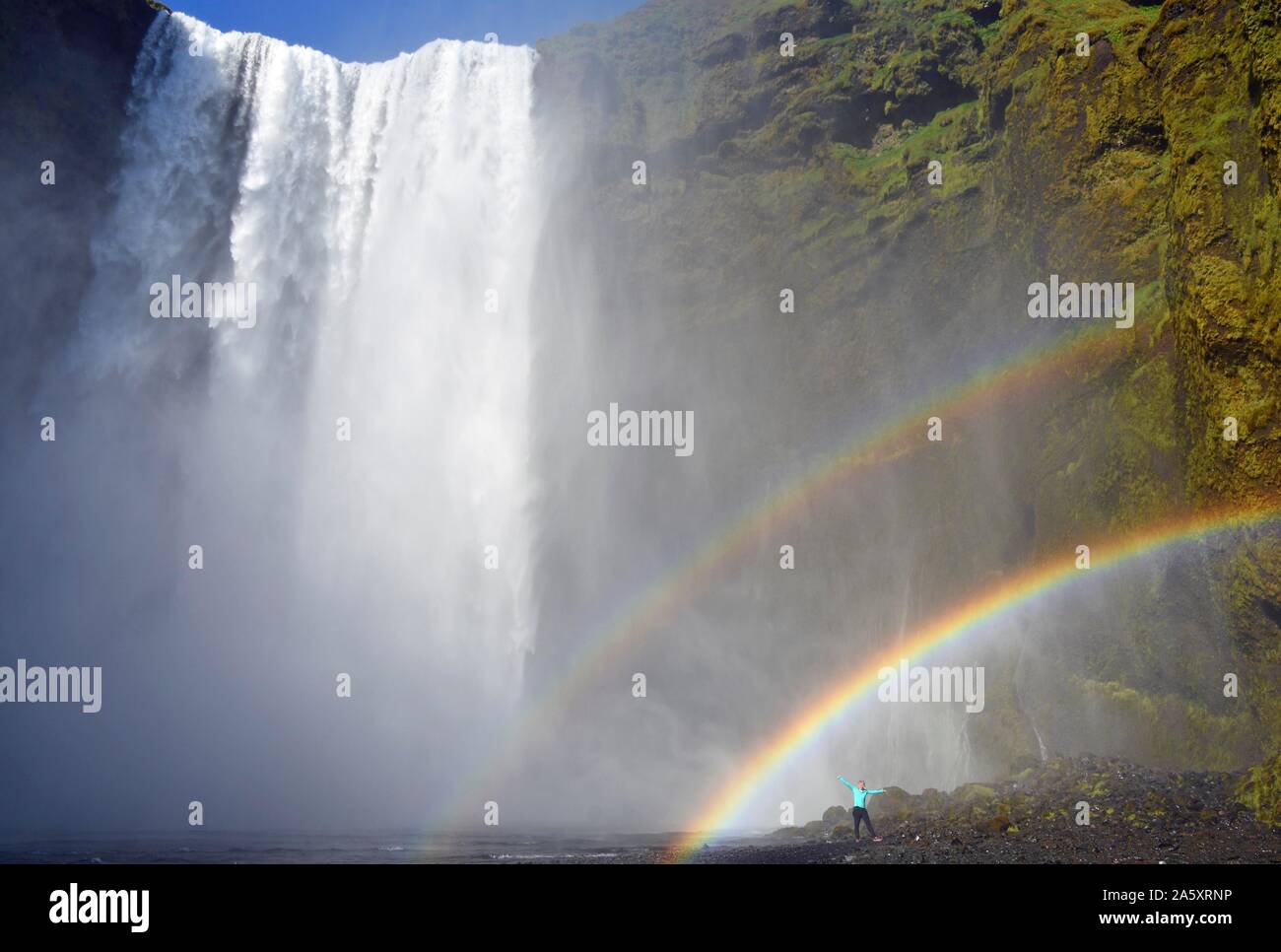L'homme se tient sous double arc-en-ciel à la grande cascade Skogafoss, Skogafoss, Skogar, ring road, Sudurland, Sud de l'Islande, Islande Banque D'Images