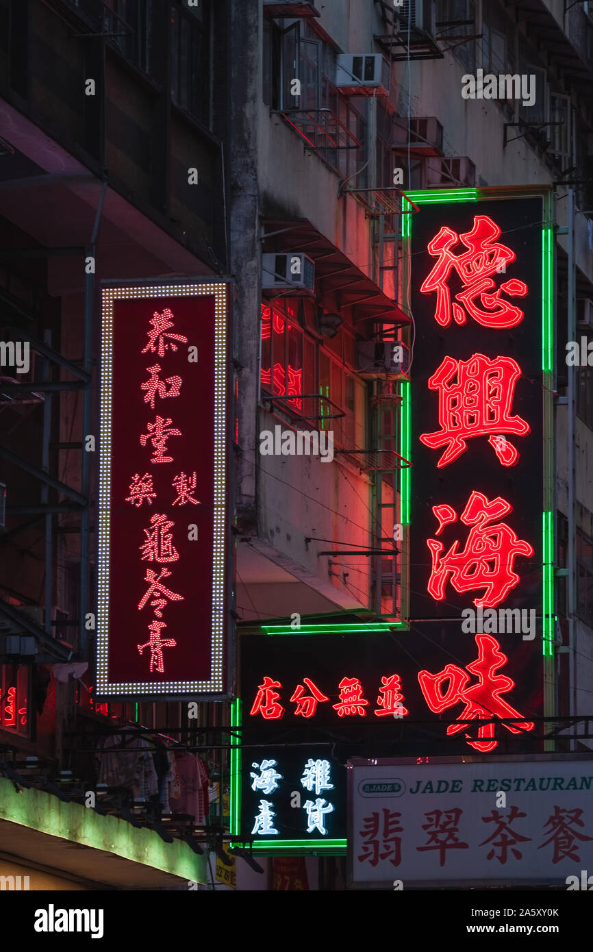 Enseignes au néon éclatantes et lumineuses l'éclairage allumé au-dessus du trafic nocturne à Kowloon, Hong Kong - Chine. Banque D'Images