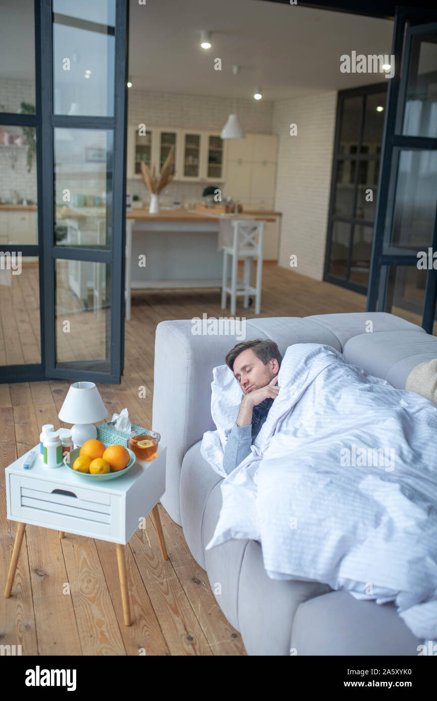 Man sleeping tout en ayant la grippe et se sentir épuisé Banque D'Images