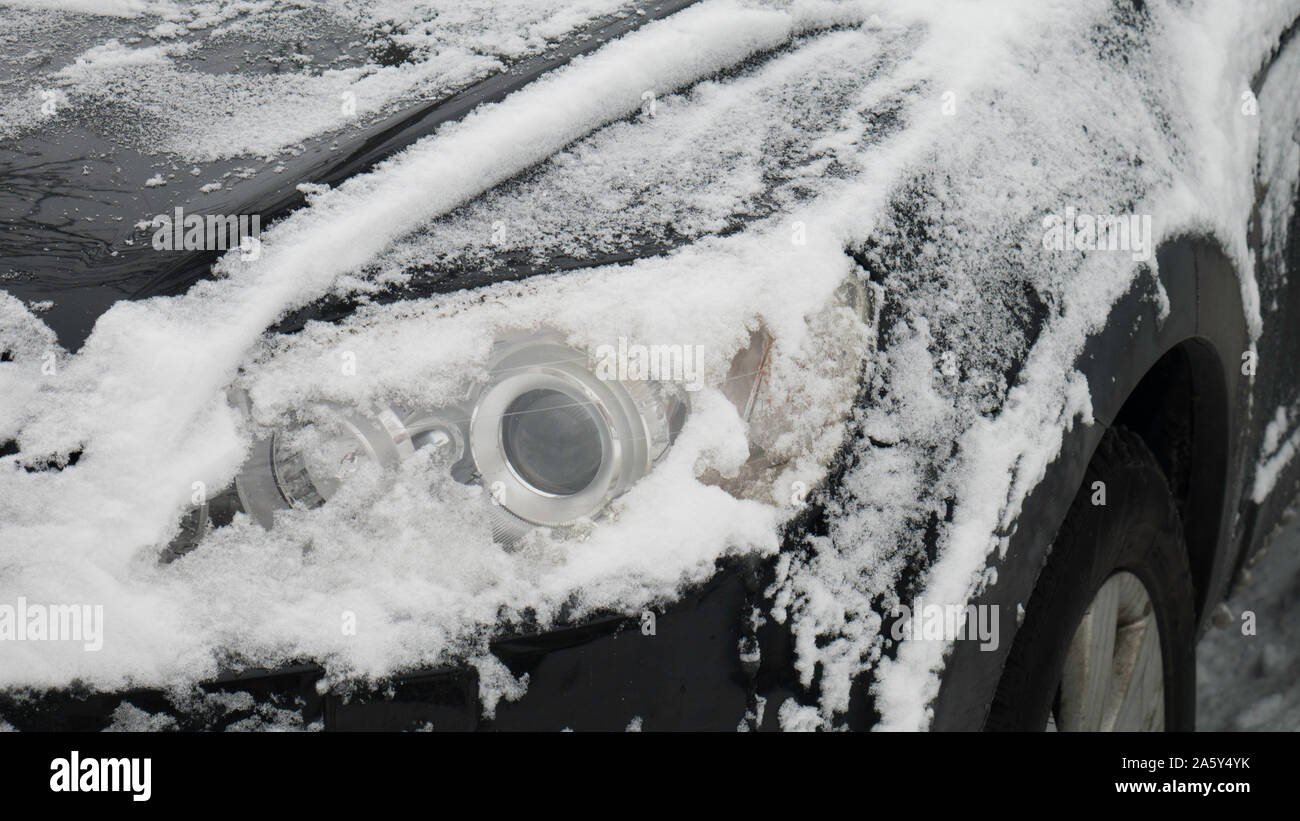 De voiture sous la neige. Phare de voiture glacée avant. icy projecteur en hiver, location de fragment. Banque D'Images