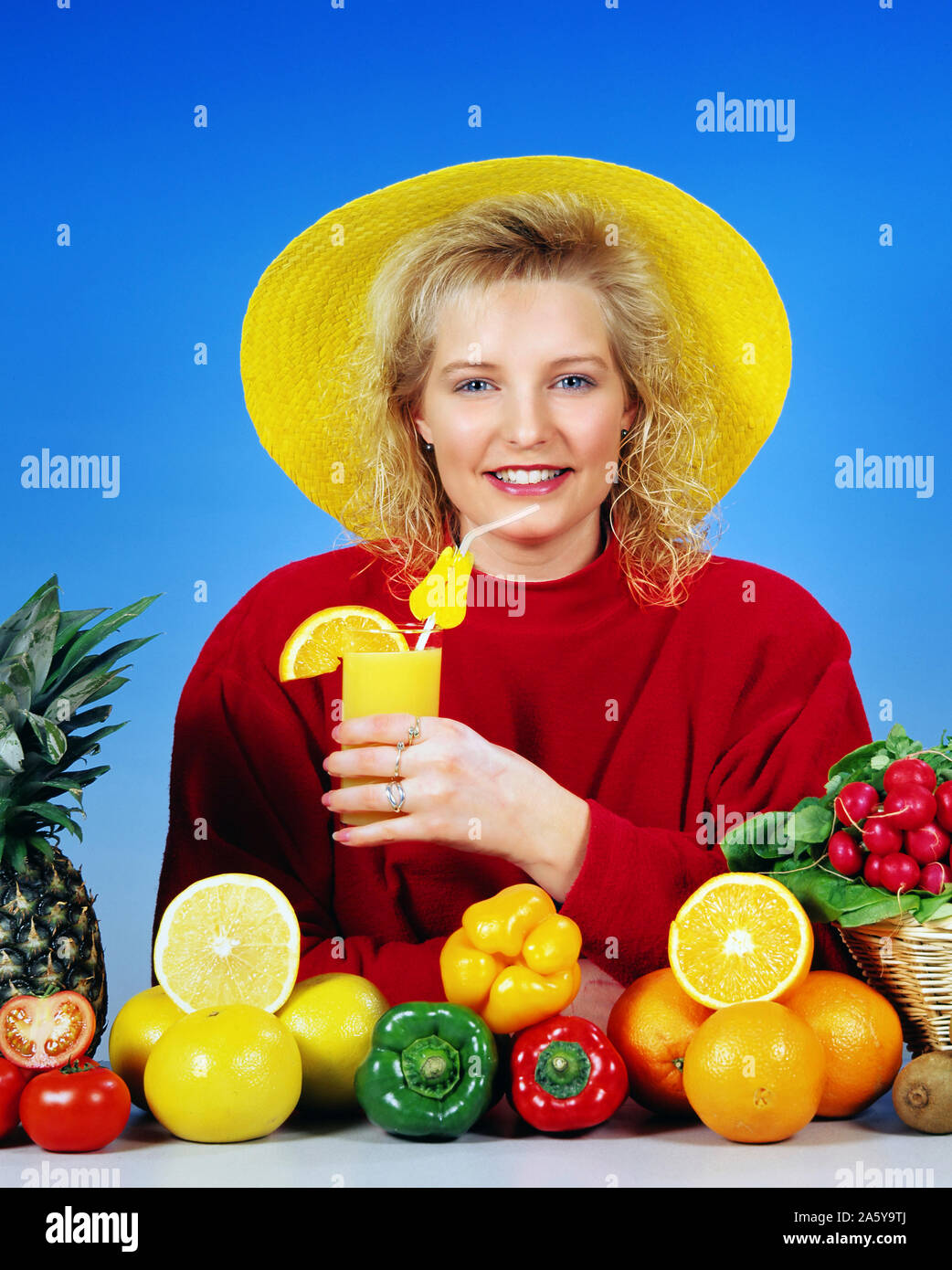 Blondes Maedchen, Gelber, Orangensaft Strohhut trinkt, im Vordergrund verschiedene Obst und, Gemuesesorten Modelrelease Studioaufnahme, vorhanden, Banque D'Images
