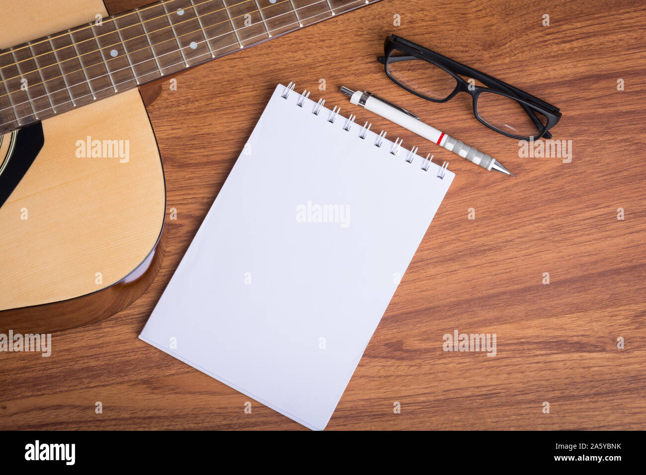 Ordinateur portable guitare, crayon et lunettes sur fond de bois Banque D'Images
