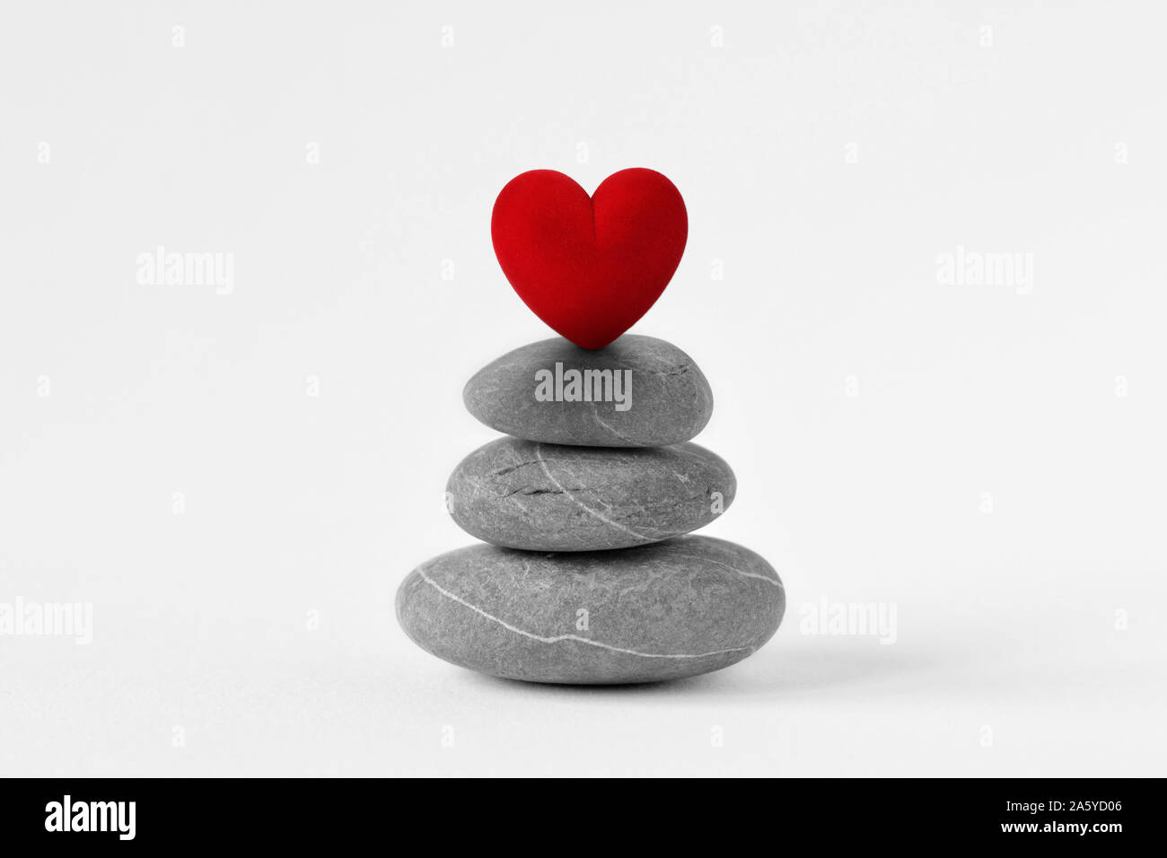 Pierres Zen empilées avec coeur sur fond blanc - Concept d'amour et de l'équilibre Banque D'Images