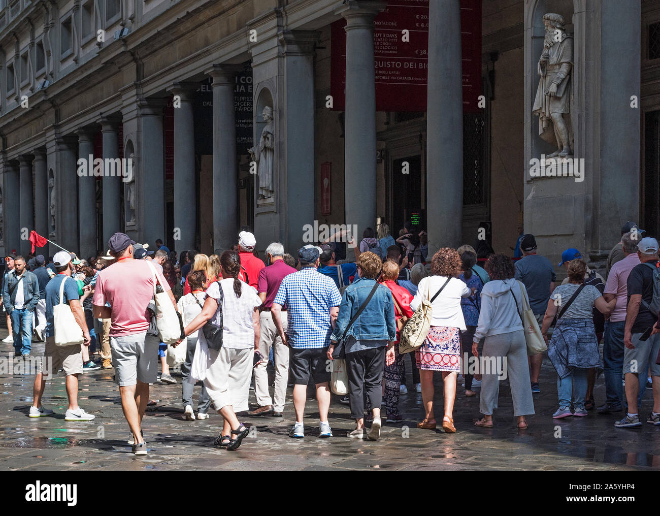 Les touristes, les groupes de visiteurs en attente de groupe dans la ligne d'attente pour entrer dans le célèbre musée d'art historique galerie des Offices à Florence Italie. Banque D'Images