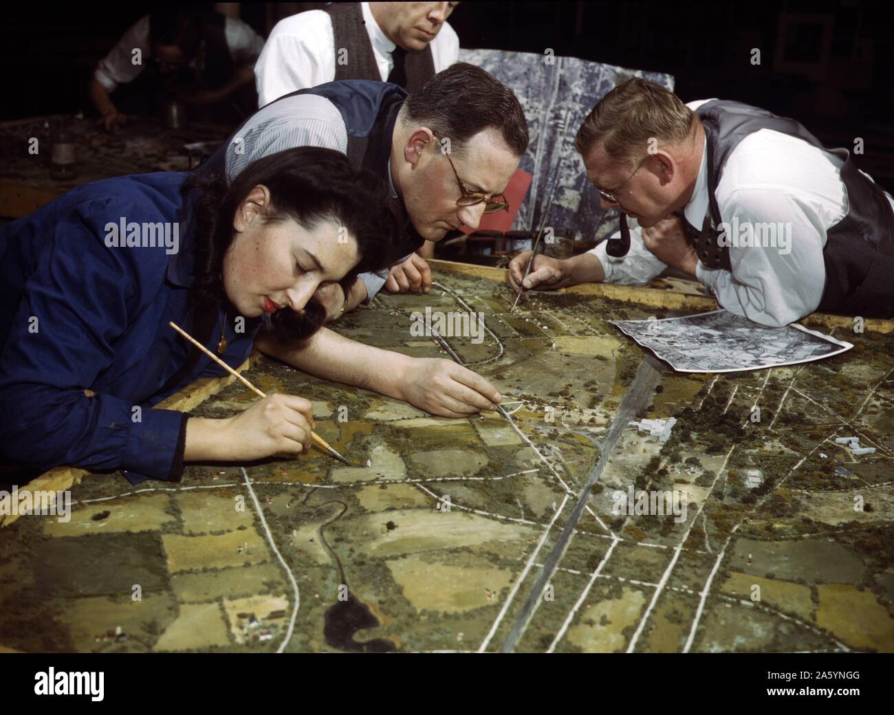 Classe de camouflage dans l'Université de New York, où les hommes et les femmes la formation pour le service de guerre dans l'armée américaine, New York, N.Y. ils réaliser des maquettes à partir de photographies aériennes, les photographier, puis l'élaboration d'un schéma de camouflage et faire une photo finale. 1943 Banque D'Images