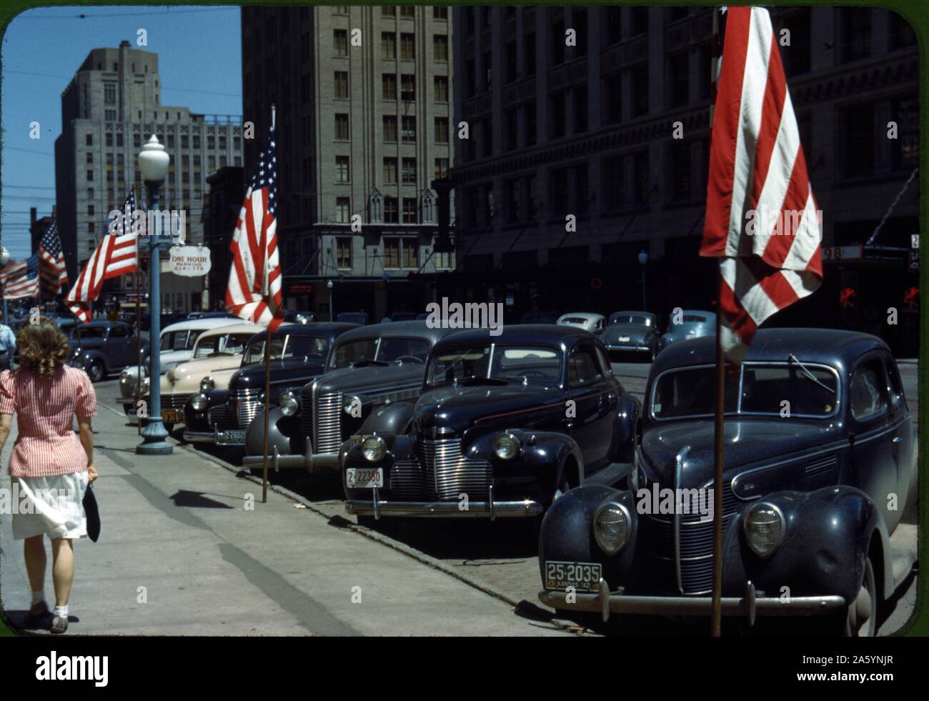 Lincoln, Nebraska USA. Scène de rue avec des voitures et des drapeaux américains pendant la Seconde Guerre mondiale. 1942 Banque D'Images