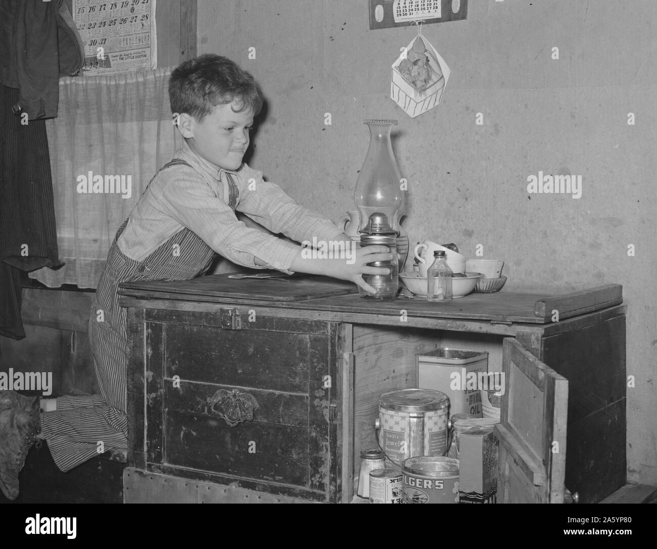 Fils de travailleur migrant pour parvenir au sommet de la lampe en cabinet accueil remorque. Weslaco, Texas. Par Russell Lee, 1903-1986, 19390101 En date du 10 févr. Banque D'Images