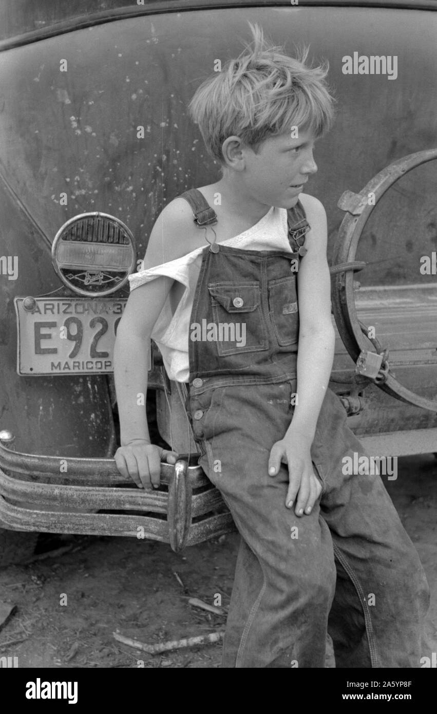 Enfant de travailleur migrant blanc assis sur pare-choc de leur voiture de l'Arizona, près de Harlingen, Texas par Russell Lee, 1903-1986, en date du 19390101. Banque D'Images