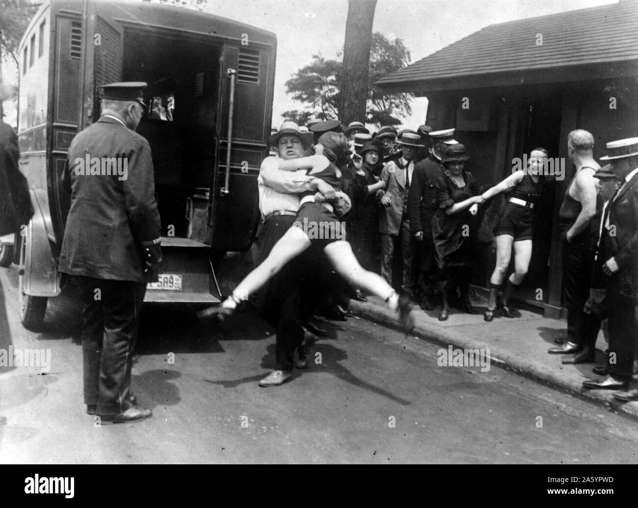 Deux femmes d'être arrêtée pour port d'echelle inappropriée des costumiers, Chicago, 1922. Banque D'Images