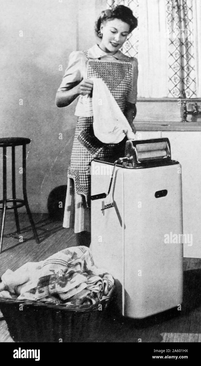 Une machine à l'essorage des vêtements parnall que de l'eau drainée de vêtements mouillés, en 1950. Banque D'Images