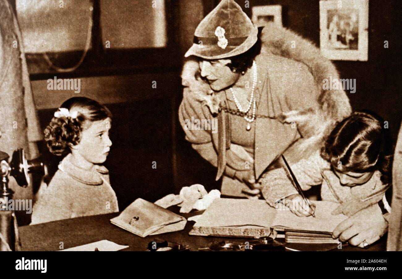 Photographie de la reine Elizabeth la Reine Mère (1900-2002) avec la Princesse Elizabeth (1926-) et de la princesse Margaret (1930-2002) lors d'une visite au Lord Roberts' Memorial Atelier pour les anciens militaires handicapés. En date du 20e siècle Banque D'Images