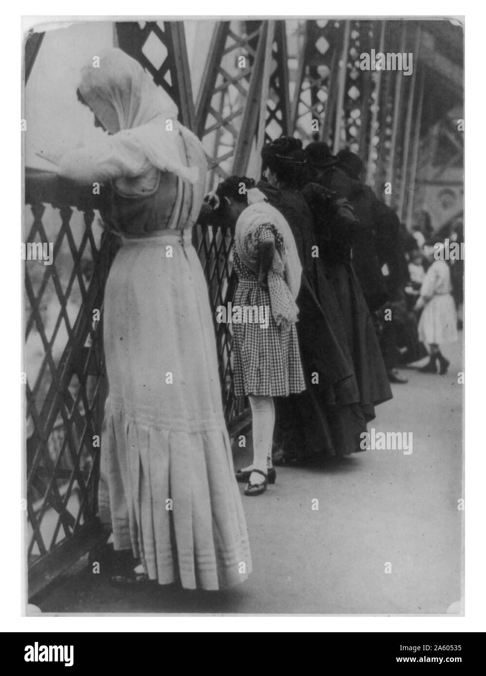 Juifs en prière sur le pont de Williamsburg, New York City, le jour de l'an 1909. La région abrite une grande population de langue yiddish et sur l'ouest de l'entrée du pont, un panneau indique 'Quitter Brooklyn ; Oy Vey !' Banque D'Images