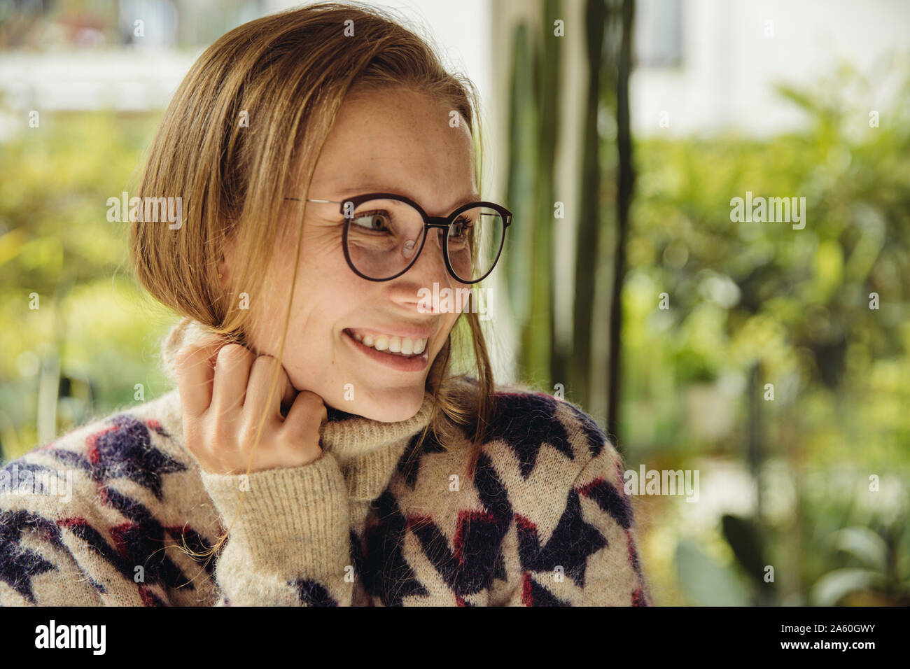 Portrait de jeune femme portant des lunettes avec pull moelleux looking sideways Banque D'Images